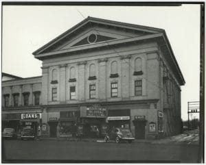 Exterior view of Sterling Theater with cars parked in front.
