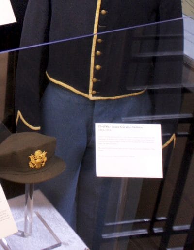 Image of a mannequin wearing a dark blue, wool, button-up jacket, and lighter blue wool pants.