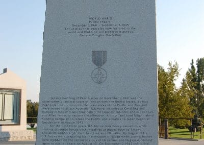 image of a large stone pillar with writing and images inscribed on it, including a map, dates of World War II, and a description of the conflict.