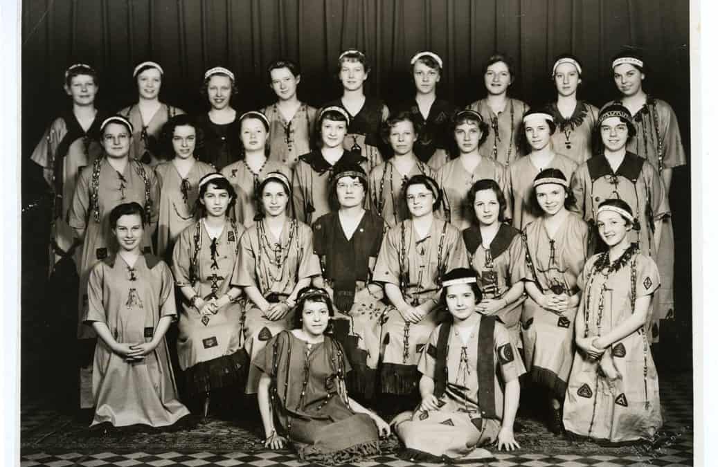 A group of Camp Fire Girls and their leader in their ceremonial gowns.